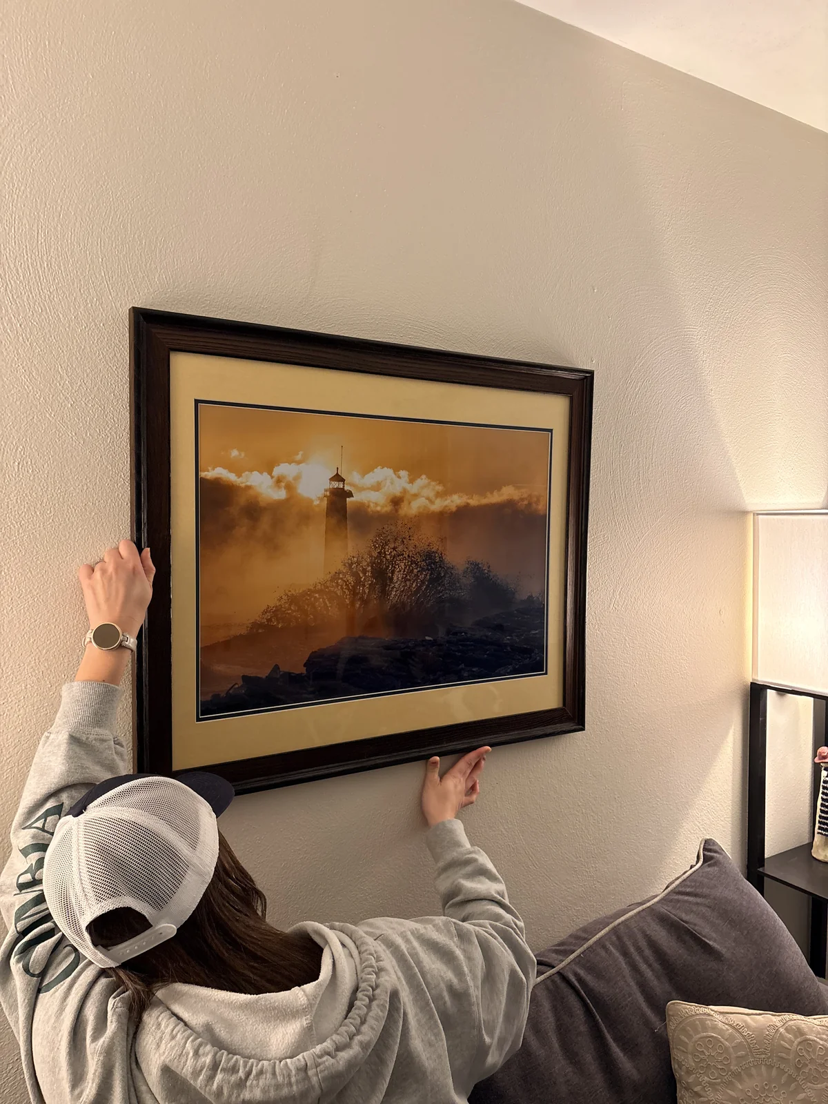 A customer hanging her framed Arctic Fury print on her living room wall